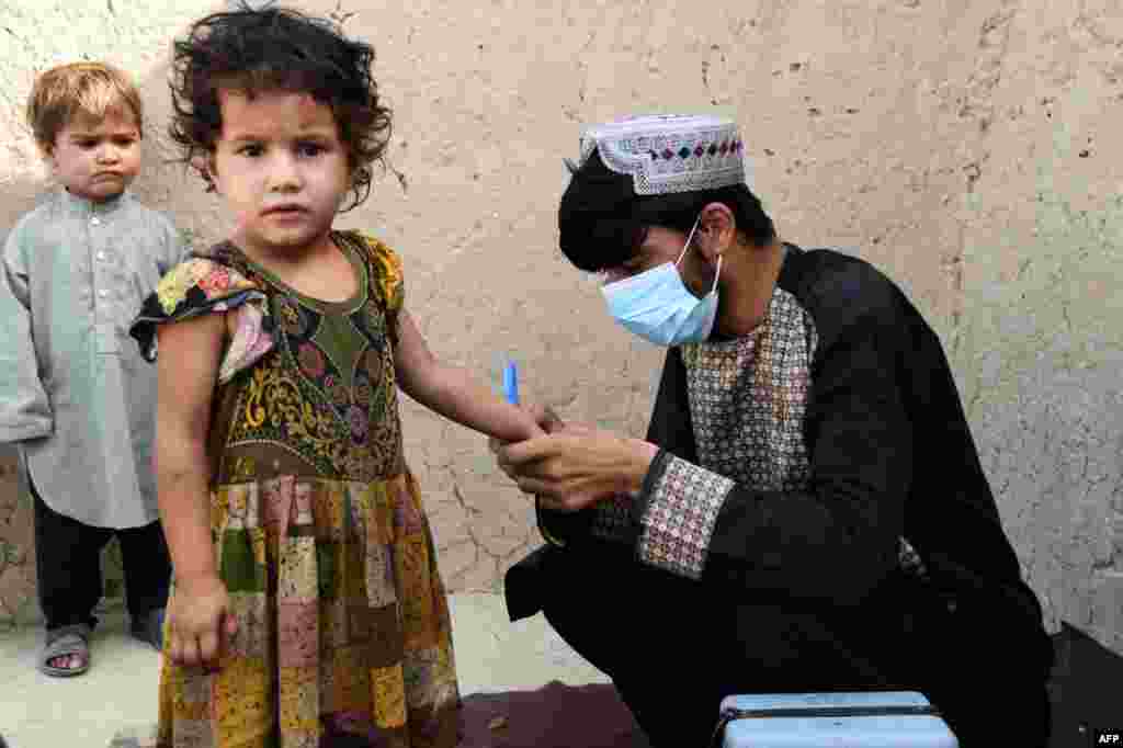 A health worker marks a child&#39;s finger with ink after giving polio vaccine at a campaign in Kandahar, Afghanistan.