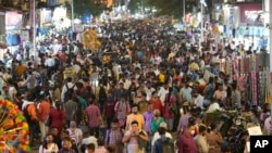 FILE - People crowd a market area outside a train station in Mumbai, India, Saturday, March 12, 2022. (AP Photo/Rajanish Kakade)
