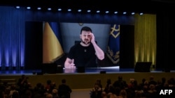 Presiden Ukraina Volodymyr Zelensky tampak di layar raksasa saat memberikan pidato pada awal konferensi internasional dua hari tentang rekonstruksi Ukraina, di Lugano, Swiss Senin 4 Juli 2022.
