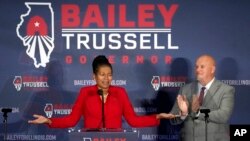 Republican lieutenant governor primary candidate Stephanie Trussell addresses the crowd as her husband, William, applauds her after she and her running mate, gubernatorial candidate Illinois state Sen. Darren Bailey, won the Republican primary June 28, 2022.