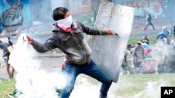 A protester returns a tear gas canister during clashes with police in downtown Quito, Ecuador, June 24, 2022. The protesters are part of a national strike that the Confederation of Indigenous Nationalities began June 14 to demand lower gas prices, price controls for agricultural products and a larger budget for education.
