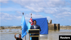 图瓦卢外长科菲(Simon Kofe)2021年11月5日站在海水里就全球气候变暖发表讲话。（路透社）