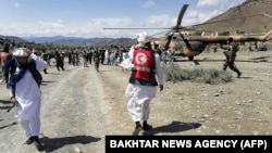22일 아프가니스탄 파크티카주 지진 발생 현장 인근에서 군 장병들과 적신월사 관계자들이 활동하고 있다.
