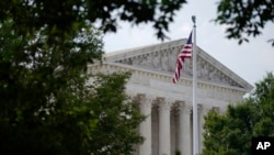 FILE - An American flag waves in front of the U.S. Supreme Court building, June 27, 2022, in Washington.