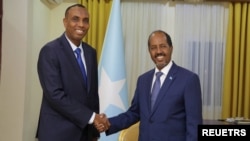Somalia's President Hassan Sheikh Mohamud poses for a photograph with newly appointed Prime Minister Hamza Abdi Barre at the Presidential Palace in Mogadishu, Somalia, June 15, 2022. 