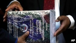 Officials hold copies of the final report of a judicial investigation into corruption in government and state-owned companies during former President Jacob Zuma's tenure from 2009 to 2018, during the official hand-over at Union Building in Pretoria, South Africa, June 22, 2022.