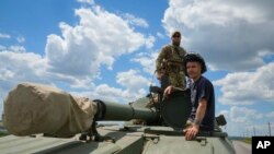 Ukrainian soldiers ride a self-propelled artillery vehicle Gvozdika in the Donetsk region, Ukraine, June 17, 2022.