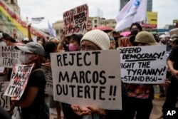 Aktivis memegang plakat menentang upacara pelantikan Presiden terpilih Ferdinand Marcos Jr saat protes di Manila, Filipina pada Kamis, 30 Juni 2022. (Foto: AP)