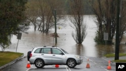 A car blocks access to a flooded street at Camden on the outskirts of Sydney, Australia, on July 4, 2022. More than 30,000 residents of Sydney and its surrounds have been told to evacuate or prepare to do so on Monday, when rain and flash floods are expected.