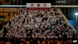 Rombongan jemaah haji berjalan di area Mina, dekat Mekah, bersiap untuk melakukan ritual melempar batu dalam prosesi pelaksanaan ibadah haji pada 9 Juli 2022. (Foto: AP/Amr Nabil)