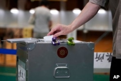 A voter casts a ballot in the upper house elections at a polling station on July 10, 2022, in Tokyo.