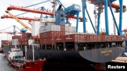 Pekerja terlihat di kapal yang membawa kontainer di Pelabuhan Tanjung Priok di Jakarta, Indonesia, 11 Januari 2021. (REUTERS/Willy Kurniawan)