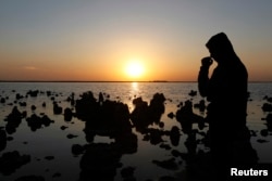FILE - A man stands next to Sawa lake in Samawa, 270 km (160 miles) south of Baghdad February 22, 2013. One of the most well-known lakes in Iraq, Lake Sawa, is a large closed body of salt water situated in the desert between Baghdad and Basra. The lake is