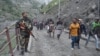 An Indian security guard keeps vigil as pilgrims cross mountain trails during their journey to the holy Amarnath cave in India. (Photo by Wasim Nabi)