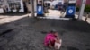 FILE - A Sri Lankan woman waits in a deserted gas station, hoping to buy kerosene oil for cooking in Colombo, Sri Lanka, May 26, 2022. Sri Lanka has run out of fuel, according to a report in Monday's Daily Mirror.