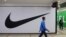 FILE - People walk past a closed store of the sporting goods retailer Nike at a shopping mall in Saint Petersburg, Russia, May 25, 2022. 