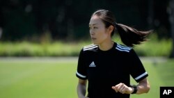 Japanese referee Yoshimi Yamashita warms up during a training session, June 27, 2022, at JFA YUME Field in Chiba, near Tokyo.