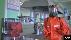 2022年6月16日，一名卫生官员在平壤化妆品工厂消毒工作场所的地板。据朝鲜国家媒体周五报道，数百个家庭患有一种不明肠道疾病，与此同时，朝鲜也在抗击新冠病毒疫情。