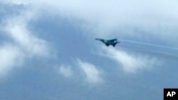 In this image taken from video, a fighter jet flies overhead and visible from Tak province, Thailand on Thursday, June 30, 2022.
