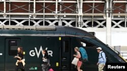 Sejumlah penumpang bersiap menaiki kereta api yang akan berangkat menuju wilayat barat Inggris di Stasiun Paddington, London, pada 20 Juni 2022. Rencana mogok kerja yang dilakukan pekerja kereta api kemungkinan besar akan berlangsung pada pekan ini. (Foto: Reuters/Toby Melville)