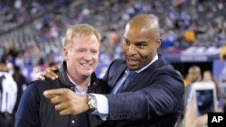 Former New York Giants defensive end Osi Umenyiora, right, talks with NFL commissioner Roger Goodell (right) before an NFL football game between the New York Giants and the San Francisco 49ers, Oct. 11, 2015