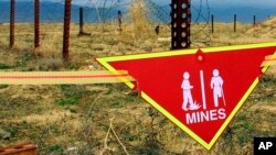 资料照：巴格拉姆空军基地雷场旁悬挂着国际地雷警告标志。（2002年3月22日）