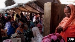 FILE - Malian refugees wait outside a food distribution center in M'Berra camp in South East Mauritania for their allocation of food assistance in Bassikounou on June 7, 2022. 
