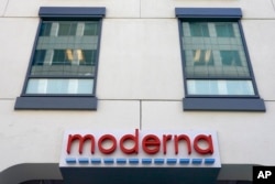 FILE - A sign for Moderna, Inc. hangs on its headquarters in Cambridge, Mass., Dec. 15, 2020.