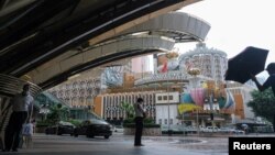 Orang-orang berdiri di dekat Casino Lisboa, di tengah wabah COVID-19, di Makau, China, 4 Juli 2022. (Foto: REUTERS/John Mak)