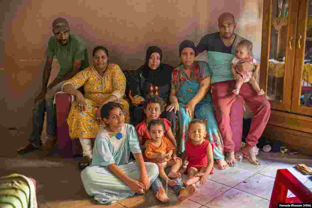 Mohamed (left) and his family live in this two-bedroom apartment. The daily wages of their household&rsquo;s three men (two pictured) help supplement rations of state-subsidized bread with unsubsidized loaves. Old Cairo, July 5, 2022. (Hamada Elrasam/VOA)