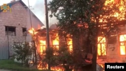 Fire burns in a building in the aftermath of shelling at a location given as Seredyna-Buda, Sumy region, Ukraine, in this screengrab obtained from a handout video released June 19, 2022. (State Emergency Service of Ukraine/Handout via Reuters)