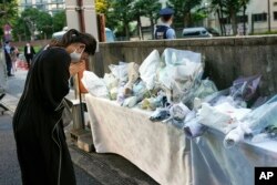 ប្រជាជន​ជប៉ុន​ដាក់​បាច់ផ្កា​គោរព​វិញ្ញាណក្ខន្ធ​លោក Shinzo នៅ​ខាង​មុខ​ទីស្នាក់ការ​គណបក្ស​ Liberal Democratic Party (LDP) ក្នុង​ទីក្រុង​តូក្យូ ប្រទេស​ជប៉ុន ថ្ងៃទី ១០ ខែកក្កដា ឆ្នាំ២០២២។