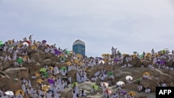 Jemaah haji berkumpul untuk berdoa di puncak Gunung Arafat, juga dikenal sebagai Jabal al-Rahma, tenggara kota suci Saudi Mekah, di saat puncak ibadah haji, pada 8 Juli 2022. (Foto: AFP/Christina ASSI)