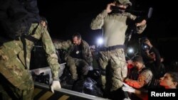 Federal Police officers transport body bags after a suspect confessed to killing British journalist Dom Phillips and Brazilian indigenous expert Bruno Pereira and led police to the location of human remains, in Atalaia do Norte, Amazonas state, Brazil, Ju