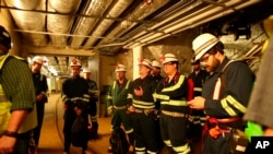Researchers at the Sanford Underground Research Facility in Lead, S.D., discuss conditions on Dec. 8, 2019 at the underground laboratory that was once used as a gold mine. (AP Photo/Stephen Groves)