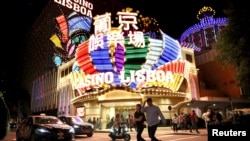 Orang-orang berjalan di depan Casino Lisboa di Macau, China, 21 Desember 2019. (Foto: REUTERS/Jason Lee)