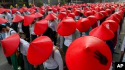 រូប​ឯកសារ៖ នៅ​ក្នុង​រូបថត​កាល​ពី​ថ្ងៃ​ទី​៣ ខែ​មីនា ឆ្នាំ​២០២១ នេះ គ្រូបង្រៀន​ដែល​ប្រឆាំង​នឹង​រដ្ឋប្រហារ​ ដែល​ស្ថិត​ក្នុង​សម្លៀកបំពាក់​ឯកសណ្ឋាន​គ្រូបង្រៀន​និង​ពាក់​មួក​ប្រពៃណី​មីយ៉ាន់ម៉ា ចូល​រួម​នៅ​ក្នុង​បាតុកម្ម​មួយ​នៅ​ទី​ក្រុង Mandalay ប្រទេស​មីយ៉ាន់ម៉ា។