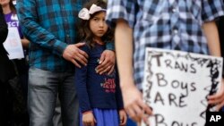 FILE - Libby Gonzales stands with her father, Frank Gonzales, as she joins other members of the transgender community during a rally on the steps of the Texas Capitol, March 6, 2017, in Austin, Texas.