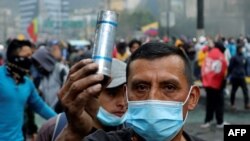 A demonstrator shows a tear gas canister shot by riot police near the House of Ecuadorean Culture in Quito, on June 21, 2022, on the ninth consecutive day of protests against the government.