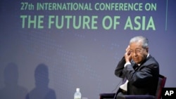 Mantan Perdana Menteri Malaysia Mahathir Mohamad membetulkan letak earphone-nya, sebelum menjawab pertanyaan pada sesi Konferensi Internasional tentang "Masa Depan Asia" di Tokyo, Jumat, 27 Mei 2022. (Foto AP/Eugene Hoshiko)