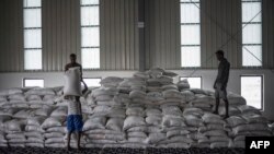 FILE - Men carry a bags of wheat in a U.N. storehouse on the outskirts of Semera, Afar region, Ethiopia, May 15, 2022. A European Union official says there is not enough fuel to distribute aid throughout Tigray, while Ethiopian officials deny the claim.