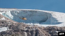 Sebuah helikopter penyelamat tampak terbang di atas gletser Marmolada, di dekat Canazei, Italia, pada 4 Juli 2022, sehari setelah gletser tersebut longsor dan menewaskan tujuh orang. (Foto: AFP/Pierre Teyssot)