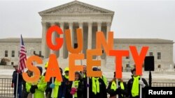 Sekelompok pendukung aturan kepemilikan senjata api berunjuk rasa bersama ratusan warga lainnya di depan gedung Mahkamah Agung AS, di Washington, pada 2 Desember 2019. (Foto: Reuters/Andrew Chung)