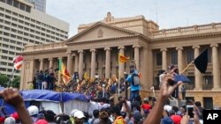 Protesters, many carrying Sri Lankan flags, gather outside the presidents office in Colombo, Sri Lanka, July 9, 2022.