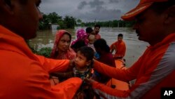 National Disaster Response Force (NDRF) personnel rescue flood-affected villagers in Korora village, west of Gauhati, India, June 17, 2022. 