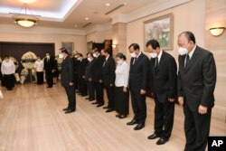 លោក​នាយករដ្ឋមន្ត្រី​ ហ៊ុន សែន (កណ្ដាល) អម​ដោយសមាជិកកំពូល​នៃ​គណៈរដ្ឋមន្ត្រី​របស់​លោក គោរពវិញ្ញាណក្ខន្ធរបស់​អតីត​នាយករដ្ឋមន្ត្រី​ជប៉ុន លោក Shinzo Abe នៅ​ស្ថានទូត​ជប៉ុន​ក្នុង​រាជធានី​ភ្នំពេញ ថ្ងៃទី ១១ ខែកក្កដា ឆ្នាំ២០២២។ (Kok Kyi/Cambodia's Prime Minister Cabinet via AP)