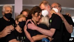 Relatives mourn as Alessandra Sampaio, center, embraces her sister-in-law Sian Phillips after speaking to the media during the funeral of her husband British journalist Dom Phillips at the Parque da Colina cemetery in Niteroi, Brazil, June 26, 2022.