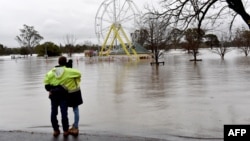 People look at a flooded park due to torrential rain in the Camden suburb of Sydney, Australia, July 3, 2022.