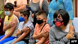 Sejumlah anak-anak berusia di bawah 11 tahun menunggu dalam proses skrining setelah menerima vaksin COVID-19 di Mekico City, pada 27 Juni 2022. (Foto: AFP/Pedro Pardo)