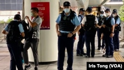 今年7月1日香港主权移交25周年，警方在湾仔一条通往会议展览中心的行人天桥上严密布防，搜查一名在场采访的摄影记者。 (美国之音 汤惠芸）
